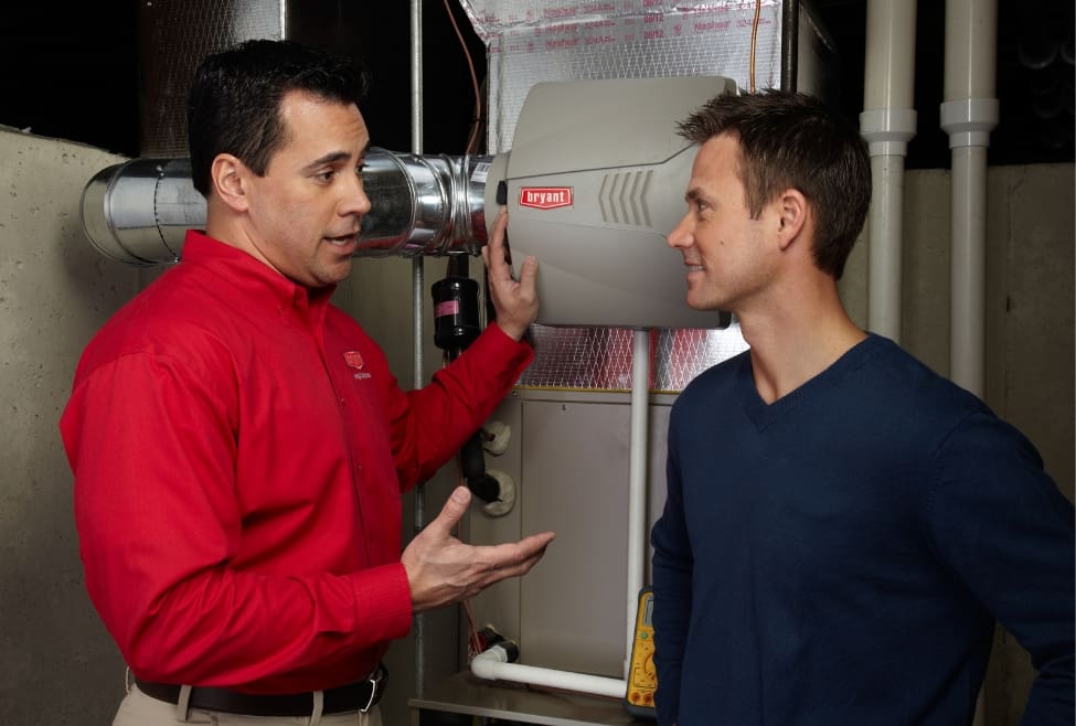 HVAC technician discussing indoor air quality solutions and humidifier installation with homeowner to prevent issues like “can air conditioning make you sick,” improve home comfort, and maintain healthy air. Services by Lochard HVAC, Plumbing, and Service include AC repair, HVAC maintenance, and air quality system installation. Call us now for help with can air conditioning make you sick, air conditioning sickness symptoms, air conditioner health risks, AC causing illness, air conditioning and respiratory problems, air conditioning allergies, HVAC air quality issues, can AC make you feel sick, air conditioner mold problems, AC humidity control, air conditioning maintenance near me, HVAC repair near me, air quality service near me, AC cleaning service, air conditioner filter replacement, indoor air quality solutions, HVAC system tune-up, air conditioner not cooling properly, air conditioning repair near me, air conditioning installation, HVAC service experts near me.