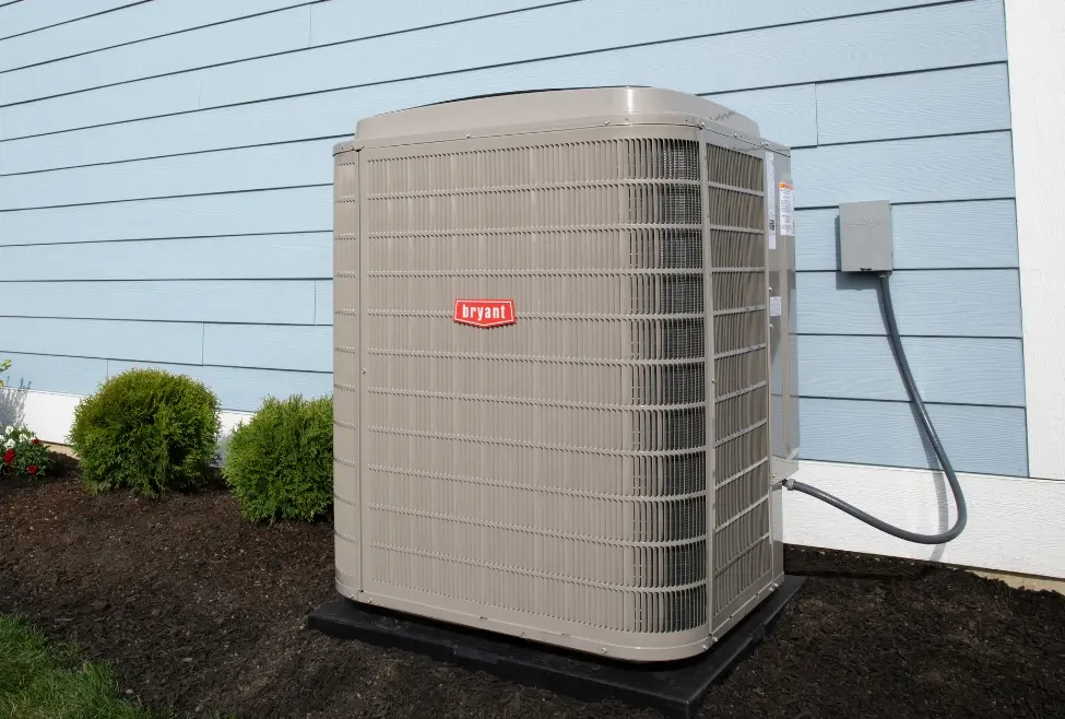 Air conditioner outside of a blue residential home, illustrating proper AC maintenance and coil cleaning tips from Lochard HVAC, Plumbing, and Service—AC coil cleaning, air conditioner maintenance, improve cooling efficiency, HVAC service near me. Call today for help with how to clean air conditioner coils, AC coil cleaning, clean AC coils at home, how to clean outdoor AC unit coils, how to clean indoor AC coils, best way to clean air conditioner coils, how to clean evaporator coils, condenser coil cleaning, air conditioner maintenance tips, AC maintenance near me, HVAC maintenance near me, HVAC coil cleaning service, professional AC cleaning services, Lochard HVAC coil cleaning, residential HVAC maintenance, how to improve AC efficiency, dirty AC coil symptoms, AC repair near me, air conditioning service near me, AC tune-up services, air conditioner not cooling due to dirty coils, how to remove debris from AC coils, HVAC cleaning near me, coil cleaning HVAC service, routine AC maintenance.